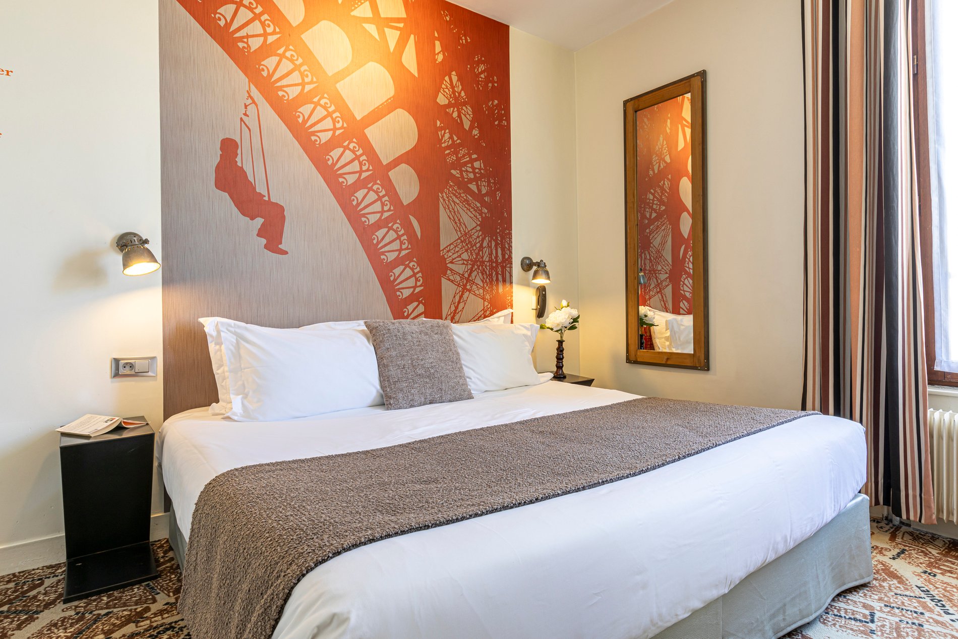 Suite Junior élégante à l'Hôtel Alpha Paris, décorée avec un motif de la Tour Eiffel, idéale pour un séjour de rêve à Paris.