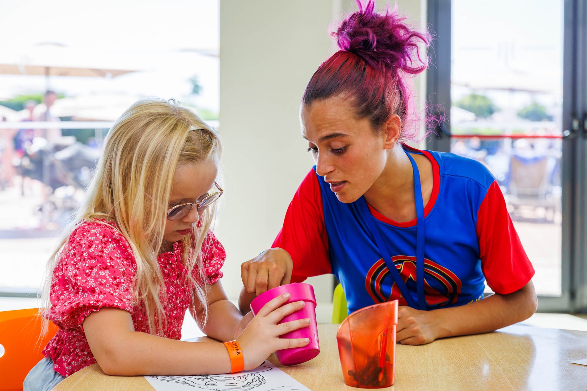 Kind zeichnet unter Aufsicht einer Betreuerin im Kids Club des Jupiter Albufeira Hotels