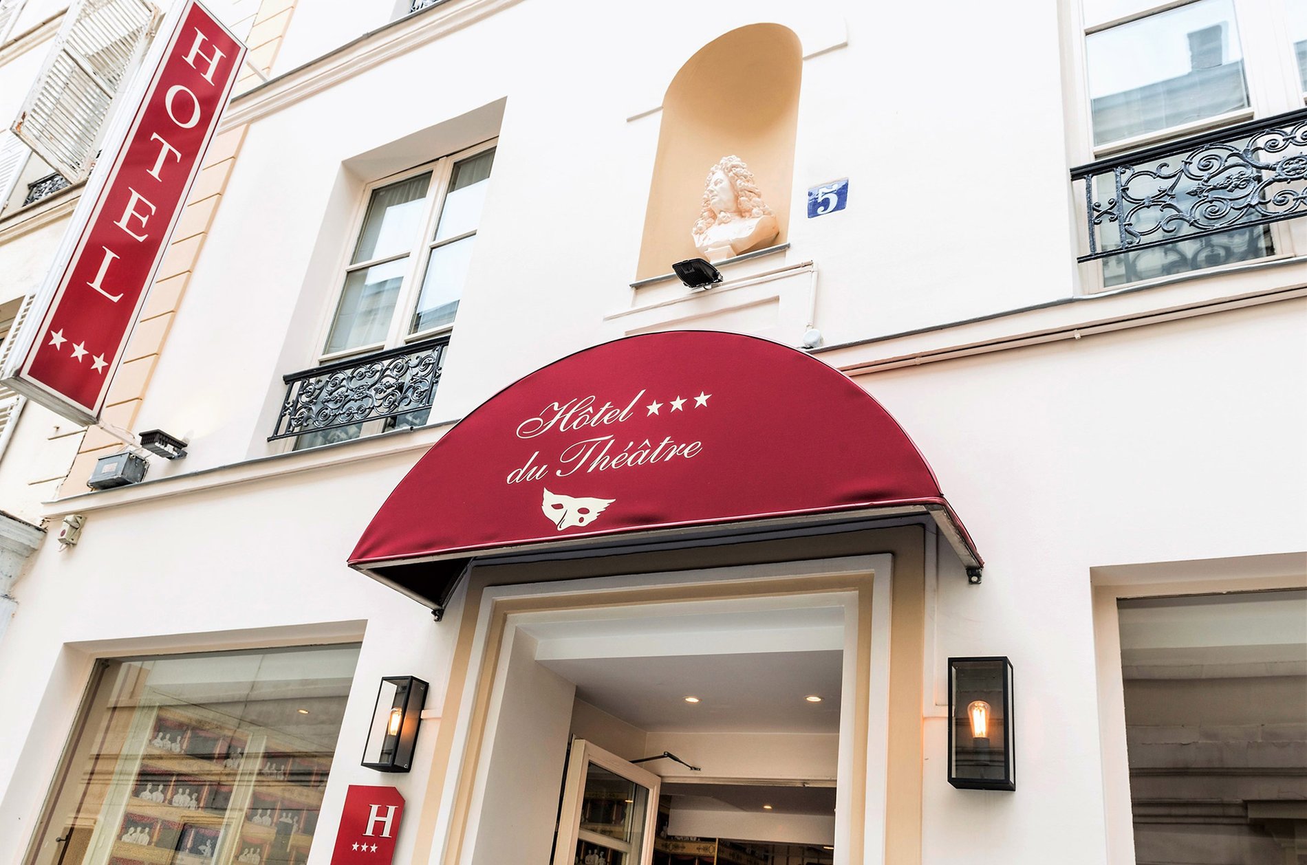 Elegant entrance of Hotel du Théâtre in Paris, offering a warm welcome to visitors.