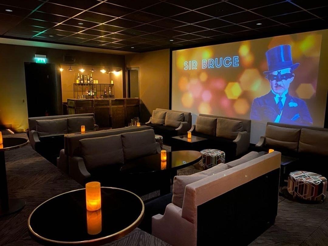 Salle de projection privée de l’Hôtel Marignan avec fauteuils confortables et grand écran allumé