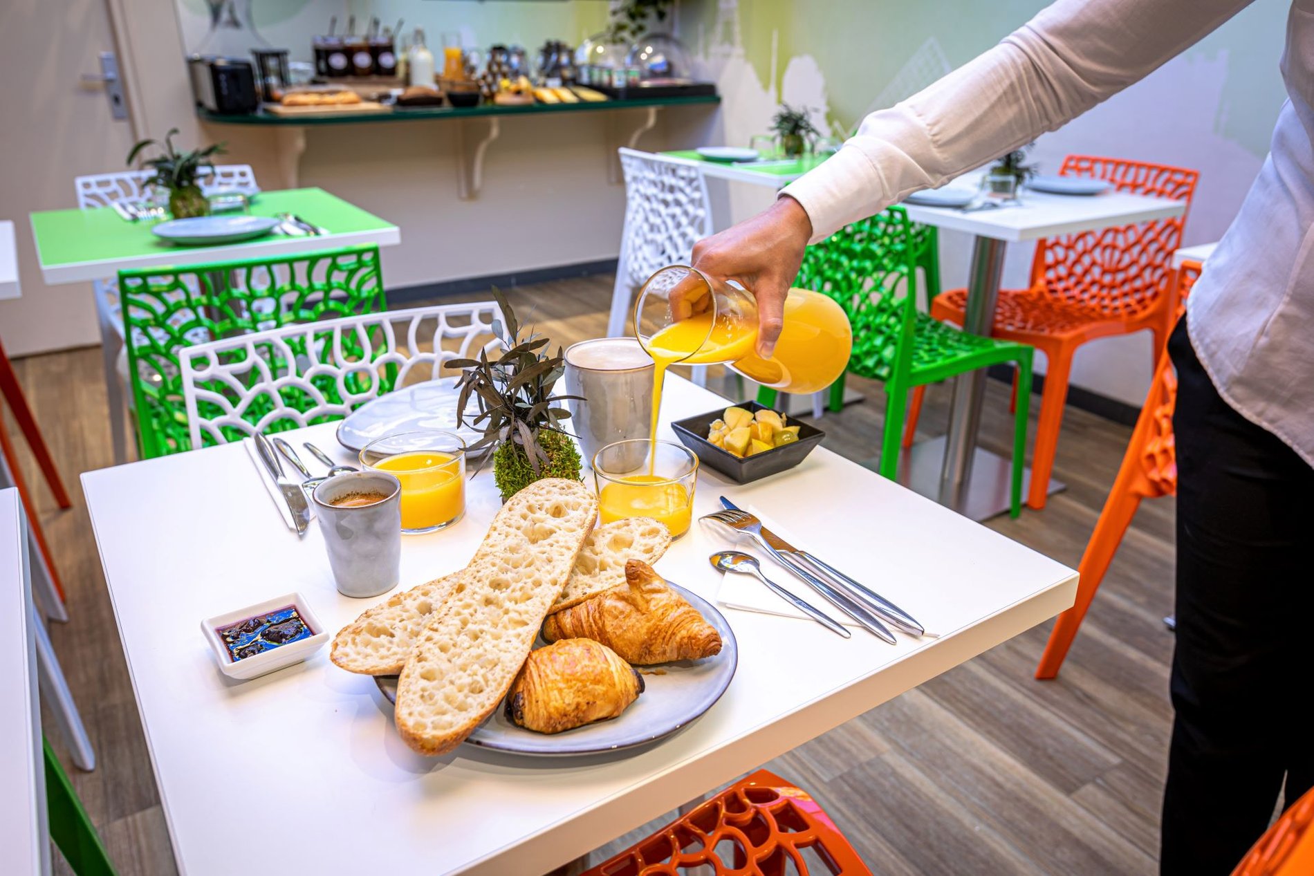 Petit déjeuner avec jus d'orange à l'hôtel Ariane Montparnasse, situé dans le 14e arrondissement de Paris, proche de la Tour Montparnasse et du Quartier Latin