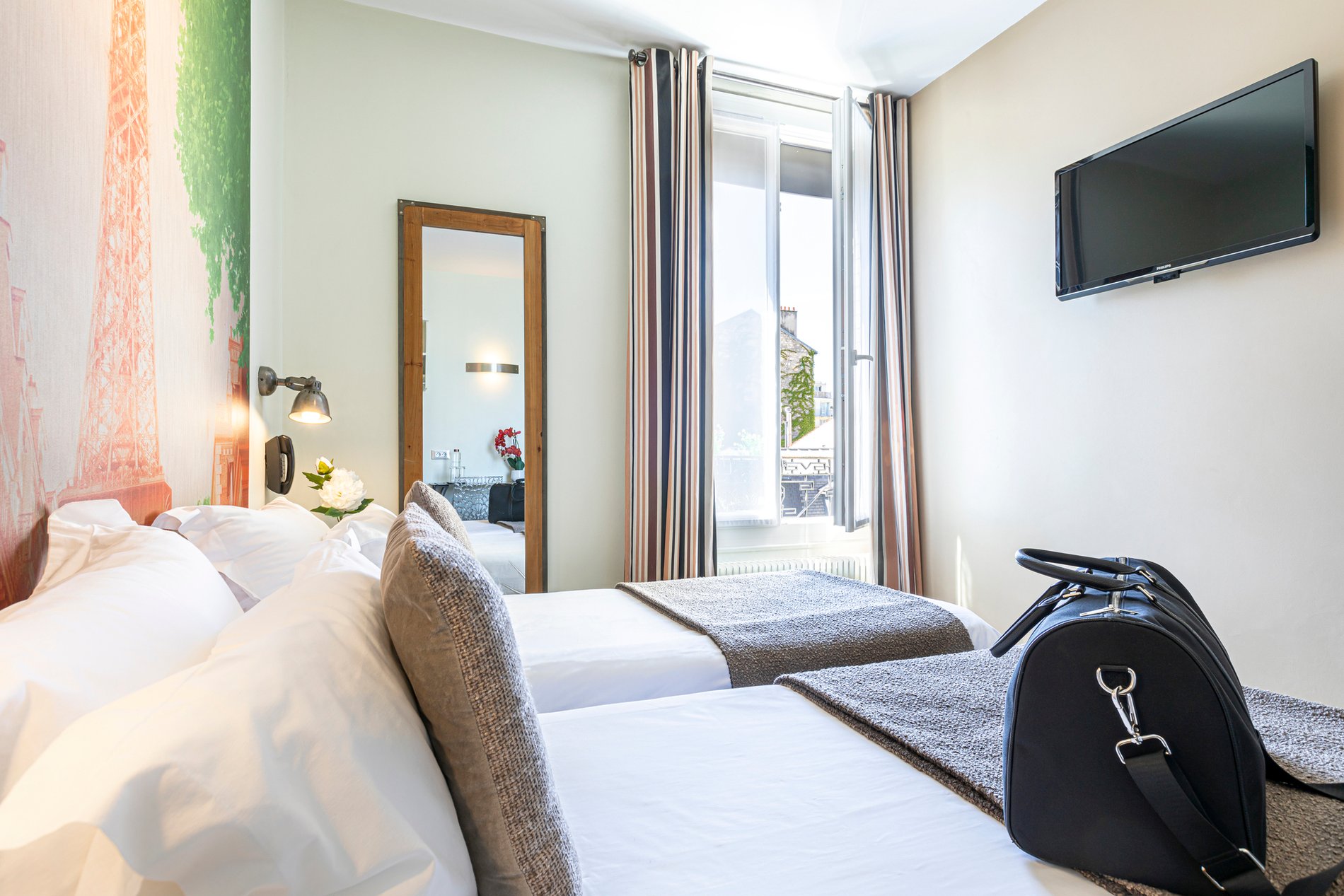 Chambre double moderne de l'Hôtel Alpha Boulogne à Boulogne-Billancourt, proche de Paris, décorée avec une fresque de la Tour Eiffel, idéalement située près du Parc des Princes et de Roland-Garros.