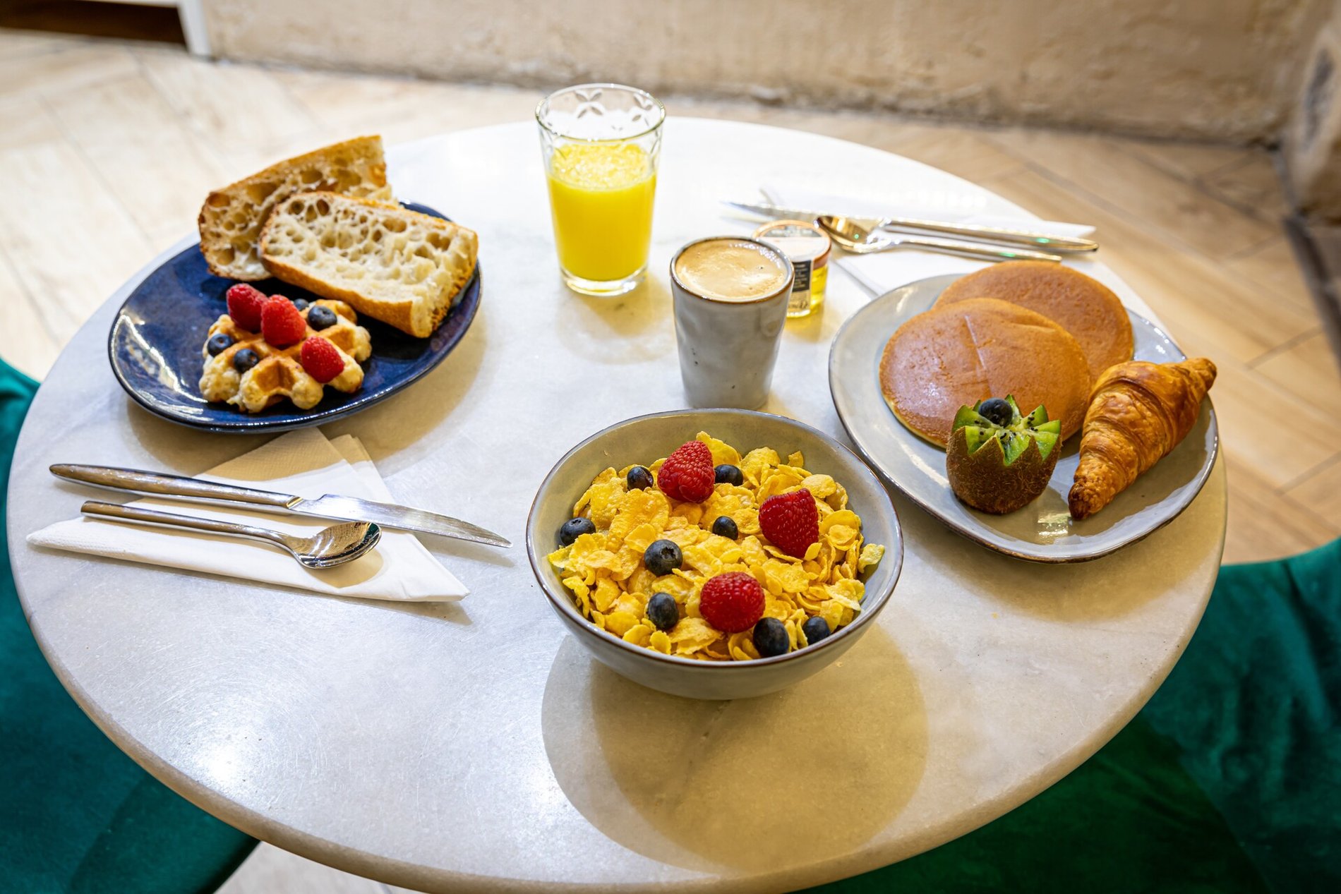 Petit déjeuner à l'Hôtel Romance Malesherbes à Paris 17ème, proche du Parc Monceau et de Montmartre. Petit déjeuner avec croissant, pain, céréales, fruits, jus d'orange et café.