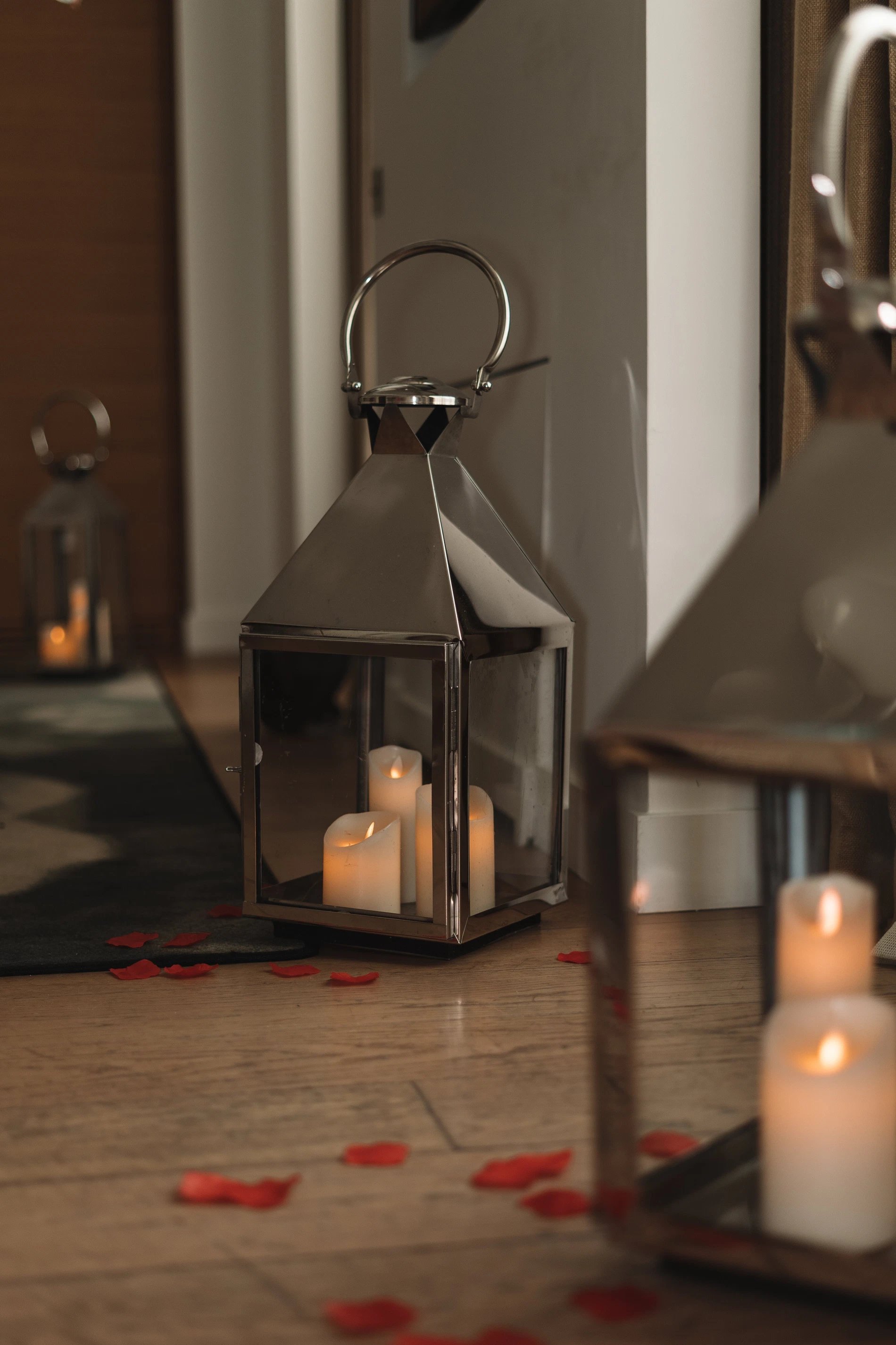 Lantern and candles surrounded by rose petals creating a romantic atmosphere
