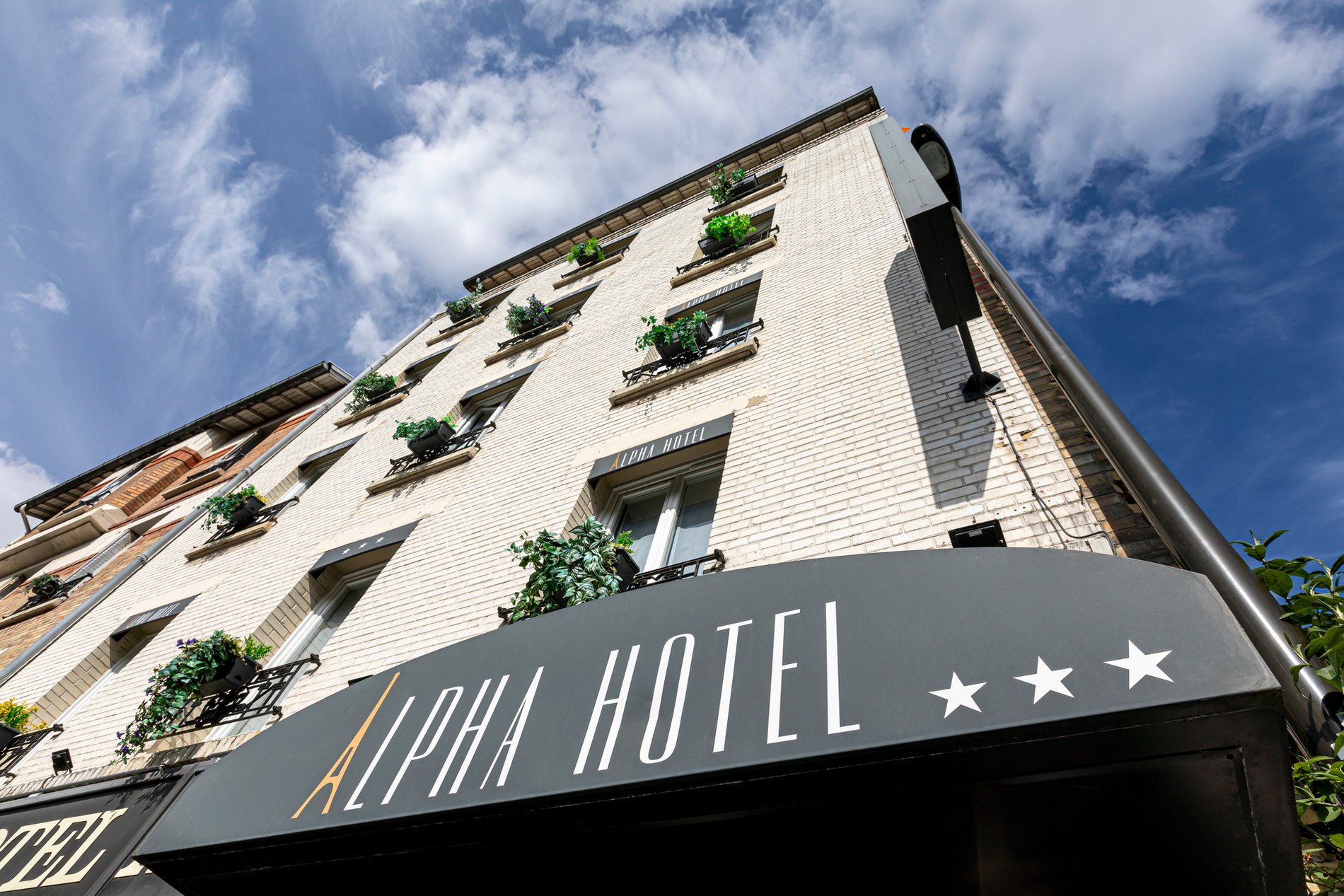 Façade de l'hôtel Alpha Boulogne, Boulogne-Billancourt, près de Paris. Proche du Parc des Princes, Roland-Garros, et la Seine Musicale. Hôtel trois étoiles.