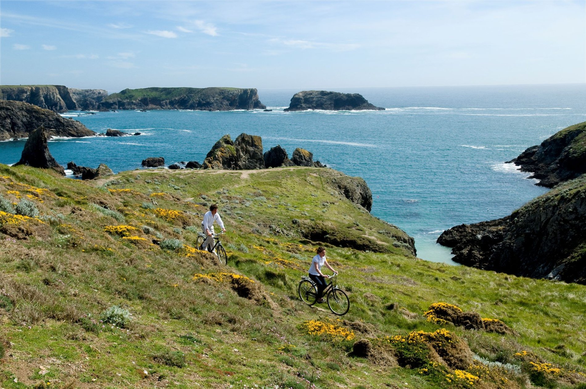 Cyclistes en randonnée sur la côte sauvage de Belle-Île-en-Mer avec vue sur l’océan Atlantique