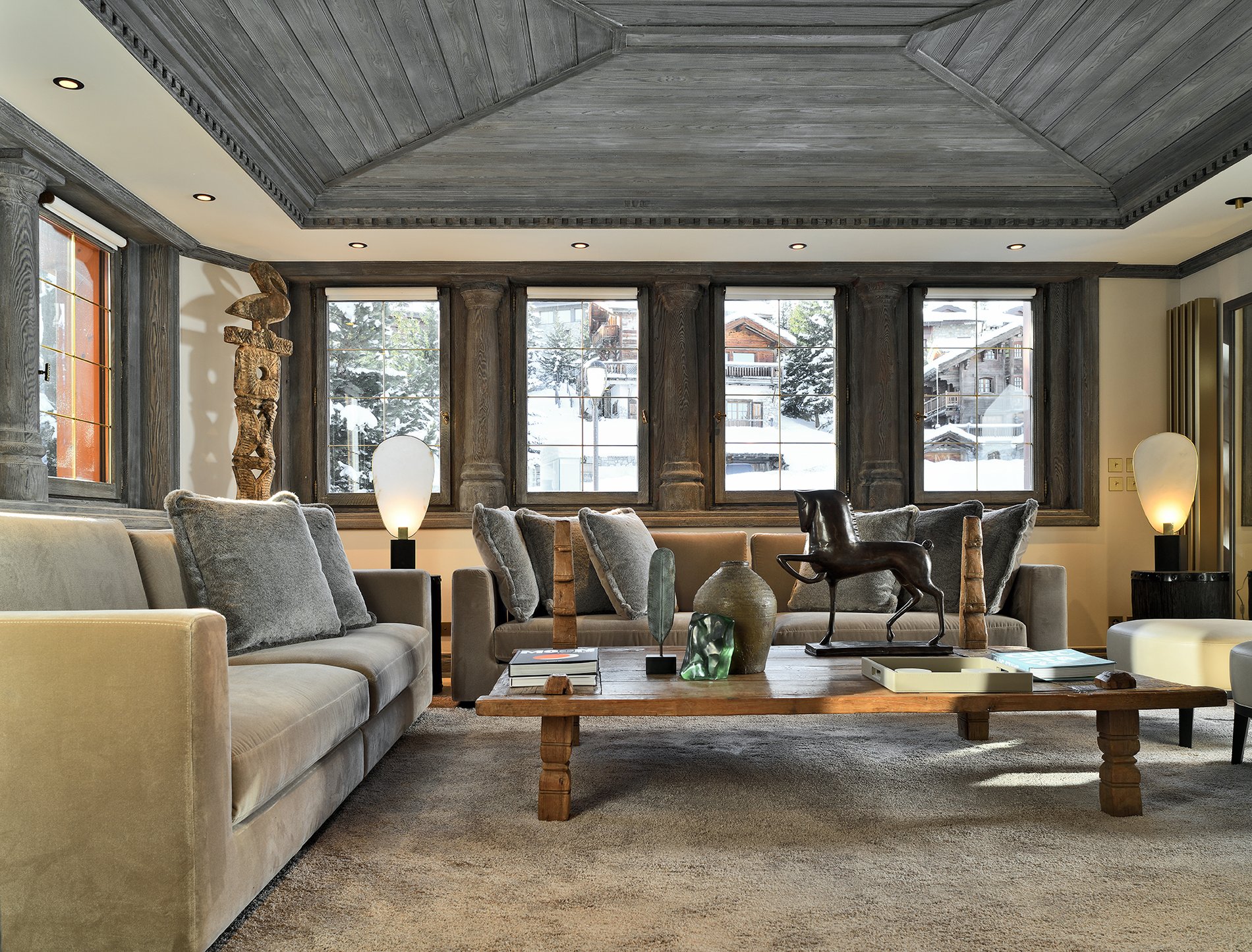 Salon spacieux et élégant d'un appartement de l’hôtel Le Strato avec vue sur les montagnes enneigées