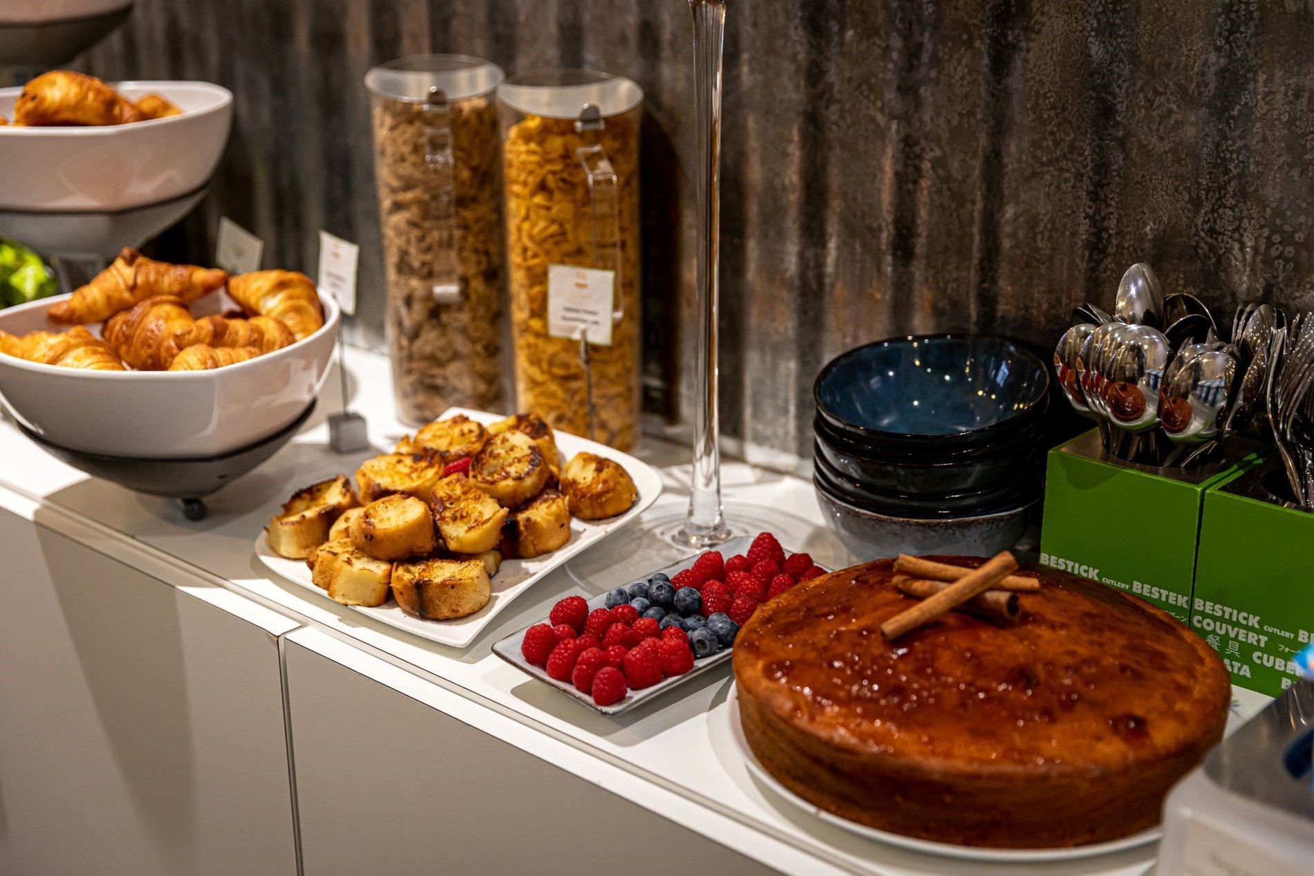 Petit-déjeuner à l'Hôtel Glasgow Monceau avec un gâteau fait maison, du pain perdu, des croissants, des céréales, et des fruits frais.