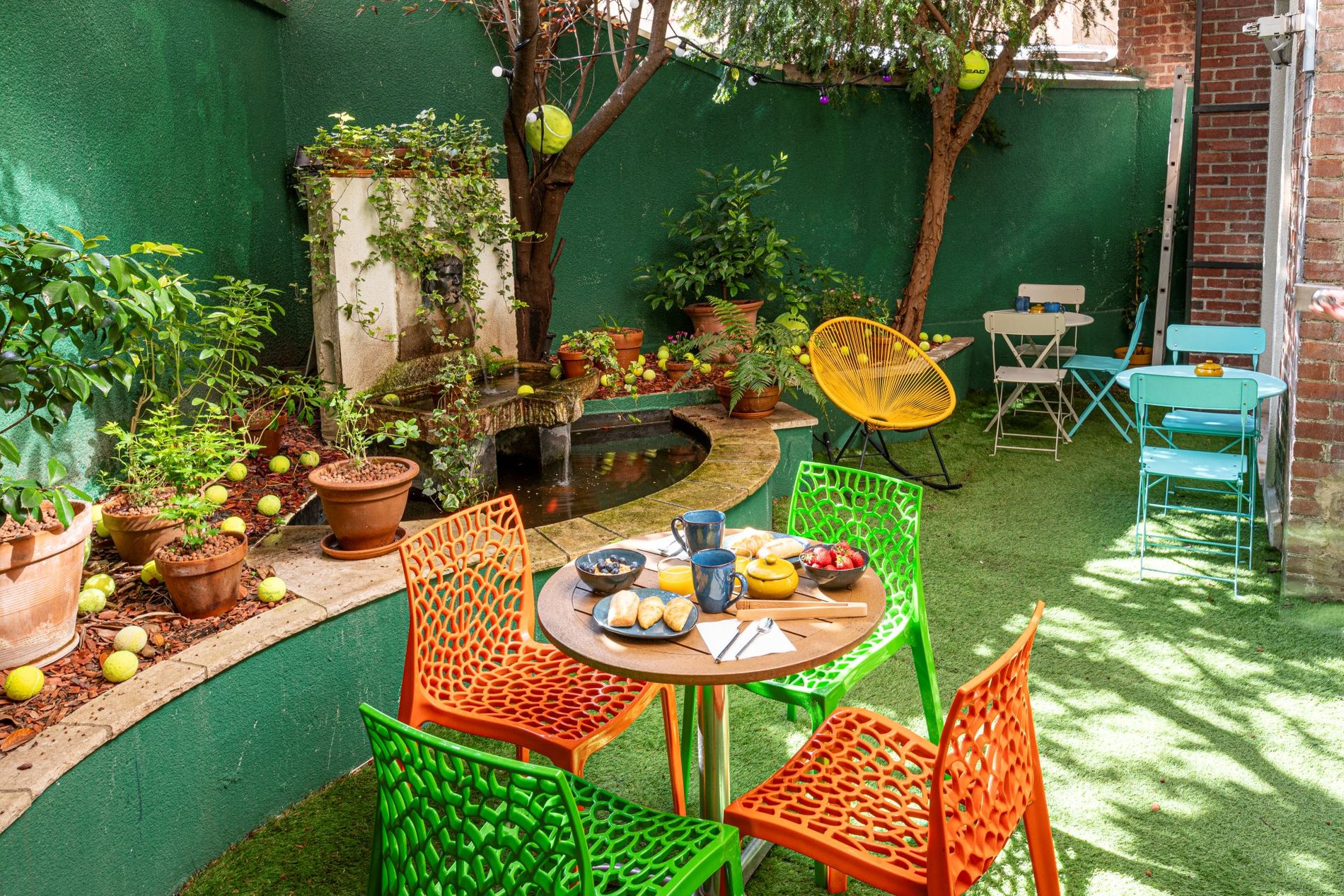 Patio verdoyant de l'Hôtel Olympic à Boulogne-Billancourt, près de Paris, parfait pour un petit-déjeuner en plein air.