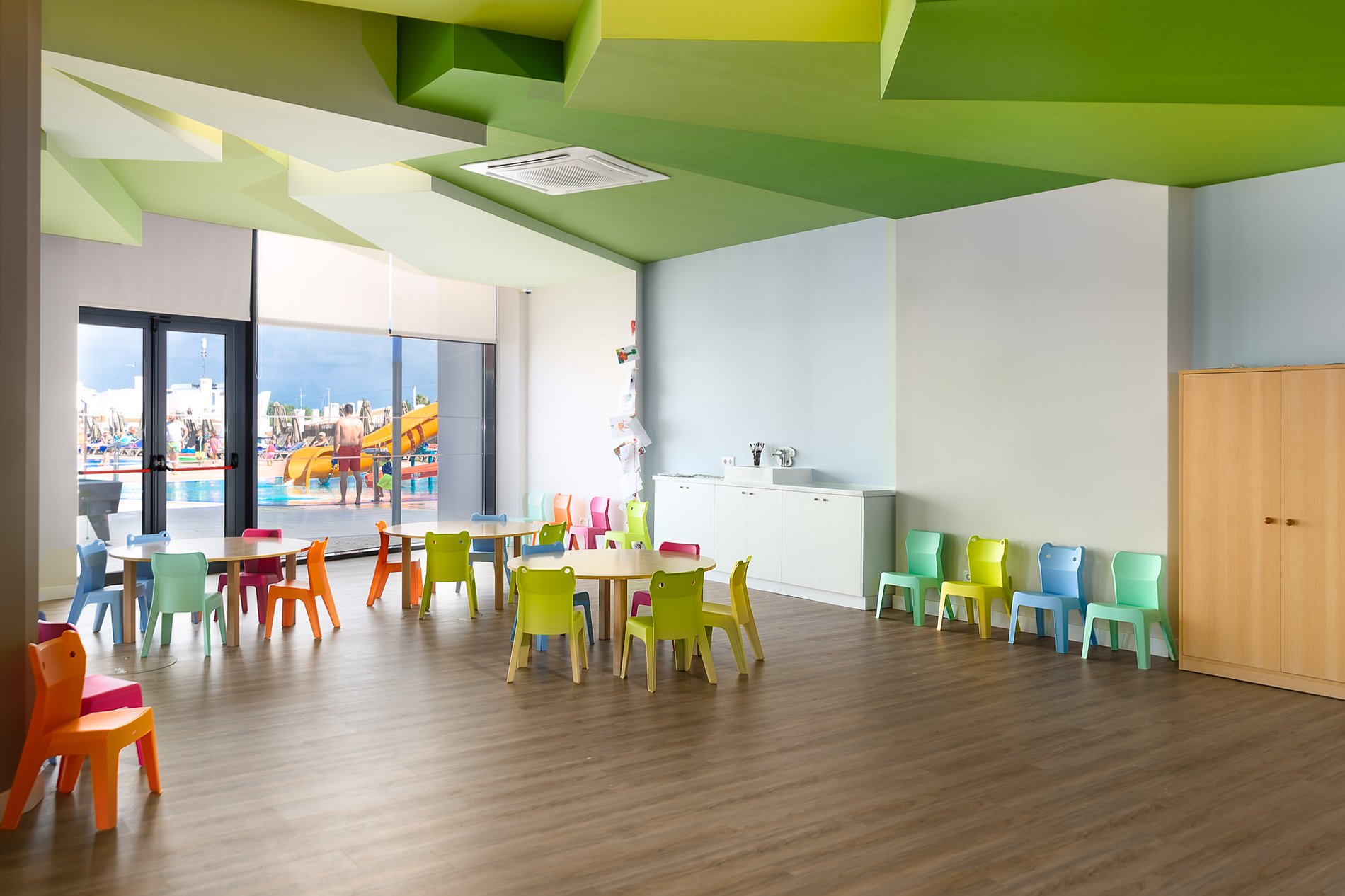 Bereich mit Tischen und Stühlen im Kids Club des Jupiter Albufeira Hotels