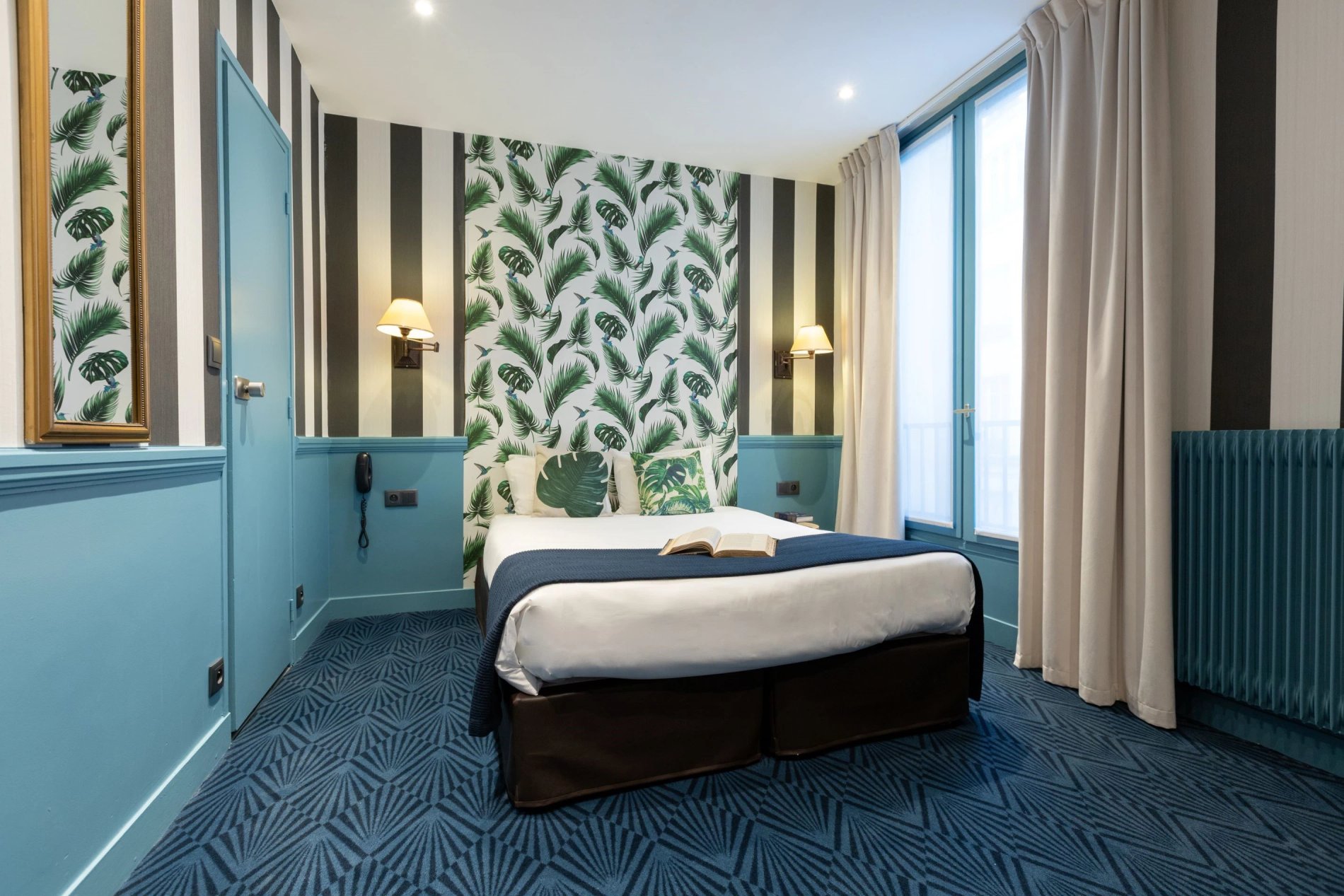 Découvrez le confort moderne dans une chambre double à l'Hôtel du Théâtre, 17e arrondissement de Paris, proche du Louvre et des Jardins des Tuileries, avec décor tropical et accents urbains chic