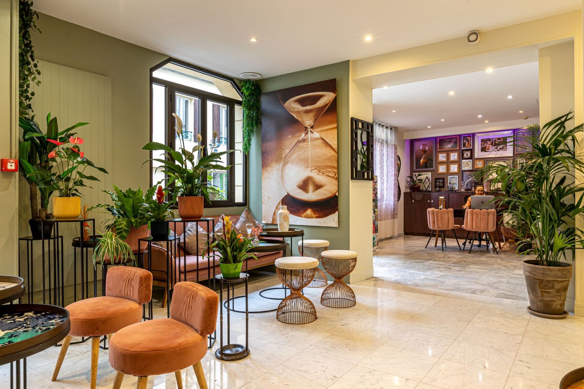 Hall d'accueil de l'hôtel Ariane Montparnasse dans le 14e arrondissement de Paris, avec des plantes décoratives, proche du Cimetière du Montparnasse et du Quartier Latin