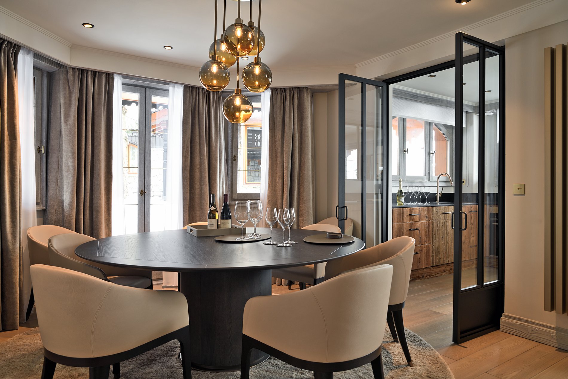 Elegant dining room in appartment at Hôtel Le Strato with round table and modern lighting